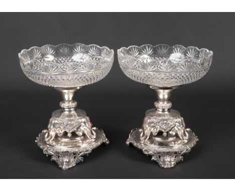 A pair of silver plated and cut glass centrepieces. Each raised on a pedestal base supported on three elephant masks on cast 