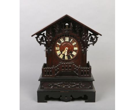 A 19th century Black Forest cuckoo mantel clock. With triangular pediment, acanthus scrolling corbels and an open fret balust