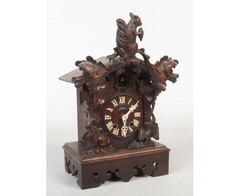 A 19th century Black Forest cuckoo clock striking on a gong. Carved with a squirrel and acanthus leaves and with white painte