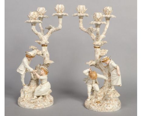 A superb pair of Royal Worcester Hadley style figural three branch candelabra. Each modelled as a tree with a naturalistic ba