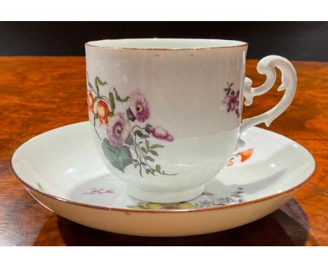 A Meissen coffee cup and saucer, painted with floral bouquets and scattered flowers, brown line rims, ear-shaped scroll handl