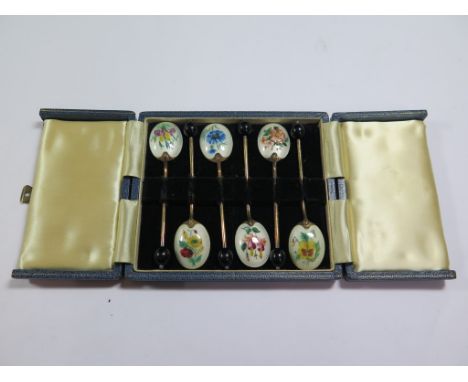 A cased set of enamel spoons