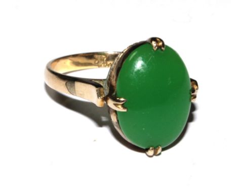 A 14 carat ring set with a cabochon jade stone