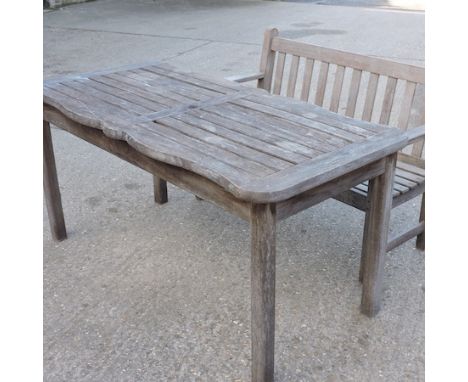 A teak slatted table, together with a similar bench, 120cm