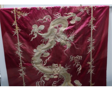 Large Chinese silk panel embroidered with a dragon chasing the pearl of wisdom within a border of embroidered bamboo, approx.