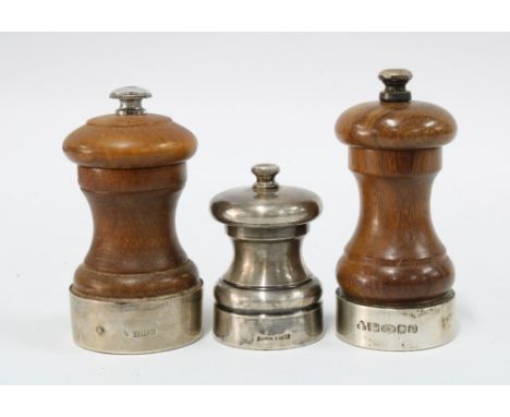 Two silver mounted pepper grinders, one with London 2004 hallmarks and the other Birmingham 1979, together with a smaller gri