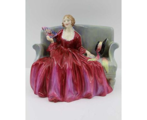 A ROYAL DOULTON CERAMIC FIGURE, "Sweet and Twenty" HN 1298, depicted with a fan seated upon a sofa, 15cm high 