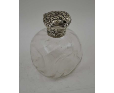 A DRESSING TABLE TOILET WATER BOTTLE, the clear dimpled glass body topped with a hinged silver cover (the cover is possibly r