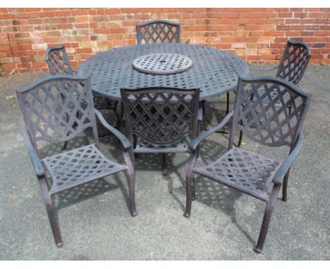 A CAST ALUMINIUM GARDEN SET, comprising a 5ft diameter table and six armchairs, of lattice design 