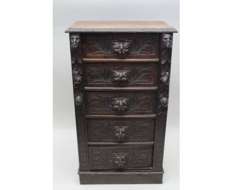 A LATE VICTORIAN OAK WELLINGTON CHEST, fitted five drawers with carved mask handles, 57cm wide x 36cm deep x 101cm high Condi