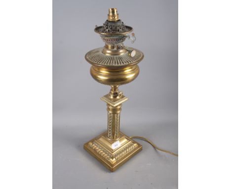 A brass oil lamp with embossed decoration, on a square base, 21" high (now converted to electricity) 