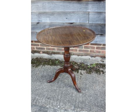 A George III Cuban mahogany circular tilt top occasional table, on vase turned column, acanthus carved tripod splay supports 