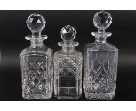 An early 20th century whisky decanter (small chips to stopper),  two other whisky decanters (tallest 10" high), a silver moun