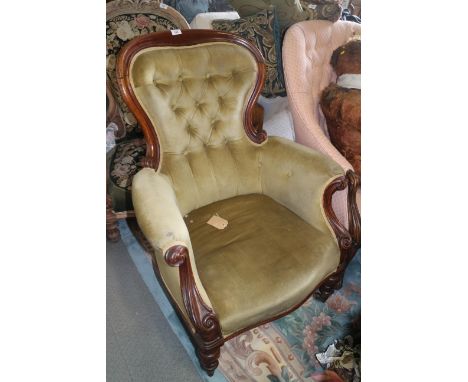 A Victorian mahogany show frame balloon back armchair button upholstered in green velour on turned and carved castored suppor
