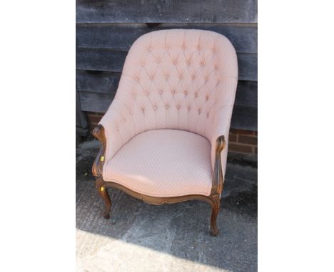 A walnut showframe tub shape armchair, button upholstered in a lattice fabric on cabriole supports 