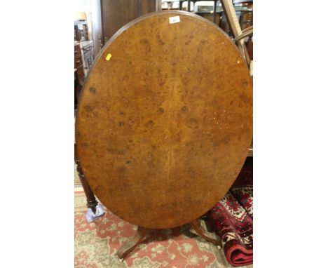 A 19th century burr walnut oval tilt top loo table, on turned column and carved tripod splay supports, 48" wide x 34" deep x 