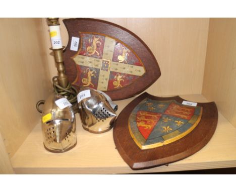 Two painted metal coats of arms on easel stands, 12 1/2" high, a brass chamberstick (now converted to a table lamp) and two m