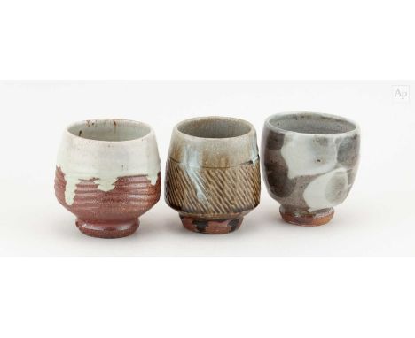 † PHIL ROGERS (1951-2020); a trio of stoneware yunomi covered in different glazes, impressed PR marks, tallest 9.5cm (3).Cond