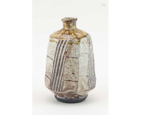† PHIL ROGERS (1951-2020); a faceted stoneware bottle covered in shino glaze with green ash top and incised decoration, impre