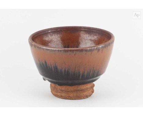 † WILLIAM STAITE MURRAY (1881-1962); a stoneware teabowl with generous foot covered in tenmoku and kaki glaze, impressed M ma