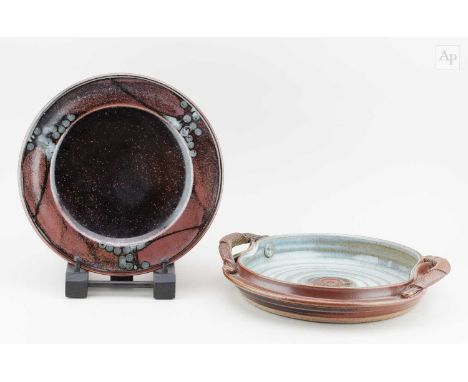 † DAVID LLOYD JONES (1928-1994); a stoneware plate covered in tenmoku breaking to kaki glaze with white spot decoration, diam
