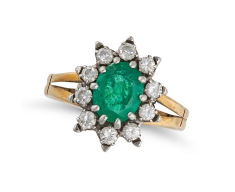 AN EMERALD AND DIAMOND CLUSTER RING in 18ct yellow gold, set with an oval cut emerald in a cluster of round brilliant cut dia