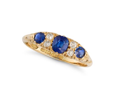 AN ANTIQUE SAPPHIRE AND DIAMOND RING in 18ct yellow gold, set with three cushion and round cut sapphires, accented by pairs o