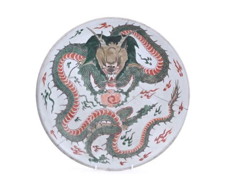 A Chinese Famille Verte 'Dragon' charger, early kangxi, painted with a sinuous dragon clutching a flaming pearl, the base wit