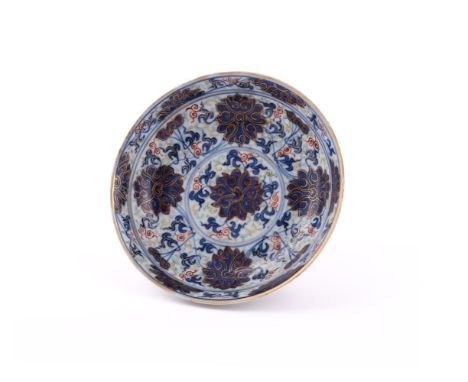A small Chinese blue and gilt 'Lotus' saucer, late 19th century, with apocryphal Kangxi four-character mark in underglaze blu