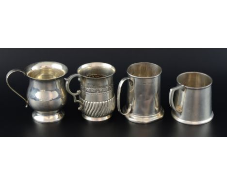 Victorian silver mug with embossed decoration and scrolling handle, London, 1886, and three other silver mugs, 11.4oz, 356g, 