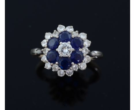 Sapphire and diamond cluster ring, round brilliant cut diamond to centre with a sapphire surround and a further border of rou