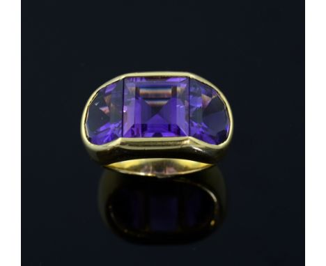 Amethyst cocktail ring. set with three amethyst, square cut to centre and a half moon cut to each side in a gold setting test