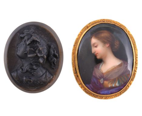  A Victorian enamel portrait brooch,   circa 1880,    the oval brooch painted with the profile of a female a Saint, within a 