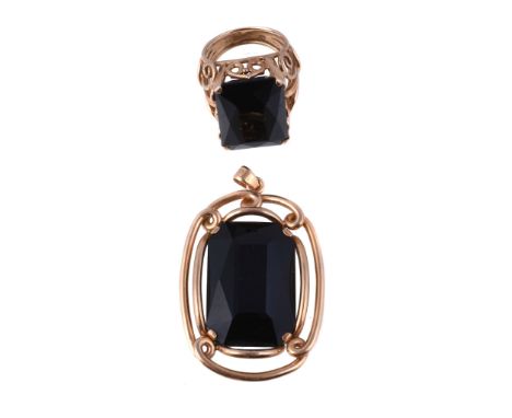  A black onyx ring,   the rectangular cut black onyx claw set, on an openwork scrolling shank, finger size O; and a black ony