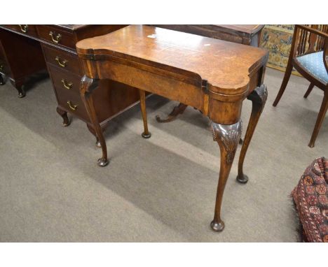 A Georgian Revival burr walnut veneered card table, the folding top with baize lined interior raised on tapering cabriole leg
