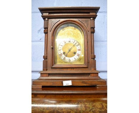 Junghans, an early 20th Century mantel clock set in an oak case of architectural style with arched brass face and a brass mov