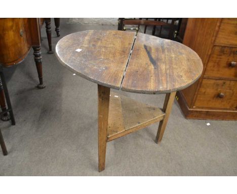 A Georgian elm cricket table with circular top over three legs and a base shelf, top 79cm diameterTop warped and stainedLeg w