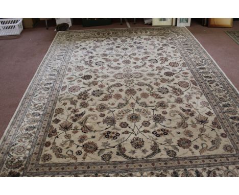 A wool carpet, beige ground within a floral border in blue and brown shades, 135" x 102"