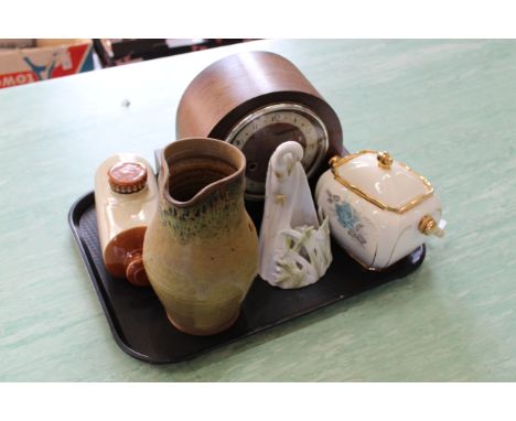 An oak cased striking mantel clock, stoneware hot water bottle, stoneware jug, a pottery biscuit barrel and a bird candle hol