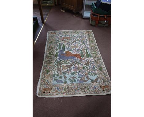 A hand sewn tapestry rug with a scene of a tiger attacking a deer surrounded by other animals, 70" x 49"
