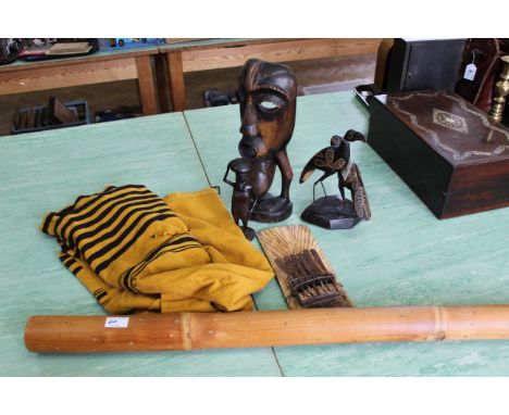 Three African carvings, a musical instrument, a bamboo rain stick and a tribal skirt