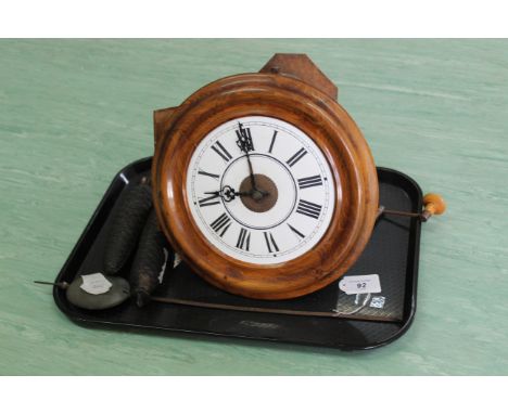 An antique wood cased hanging wall clock with two weights and chains, pendulum and bell