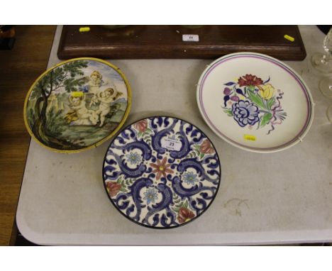A Poole Pottery floral decorated plate together with a pottery plate decorated with cherubs and one other pottery plate