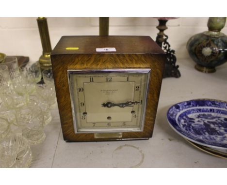 A mid 20th Century oak cased three hole mantel clock by the Goldsmiths & Silversmiths Company Ltd., with presentation plaque