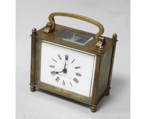 A 'Eureka' gilt brass carriage clock, with white enamelled dial, in outer wooden carrying case
