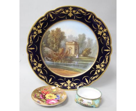 A Sevres cabinet plate, painted with a view titled to underside 'Pavillon de Musique à Trianon', within a dark blue and gilt 