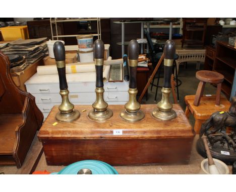 Four vintage beer pumps contained on wooden base