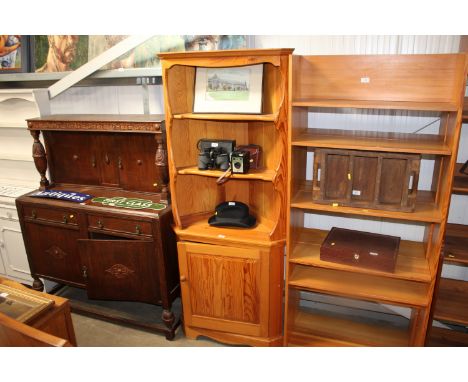 A light Ercol corner unit raised on cupboard base