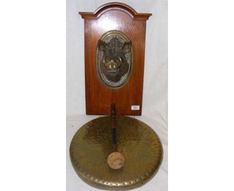 A 36cm diameter brass dinner gong, the oak support mounted with ornately cast bronze Boar's head