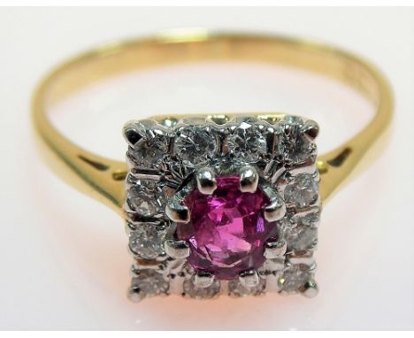 18ct hallmarked gold platinum set diamond and ruby cluster ring, the central ruby of 0.30ct spread approx, surrounded by twel